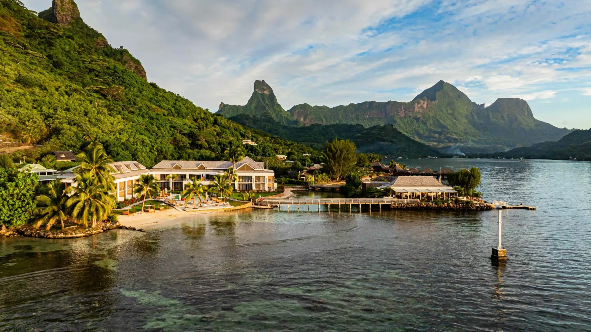 Vue aérienne de l'hôtel Cook's Bay au bord de la baie, au pied des montagnes