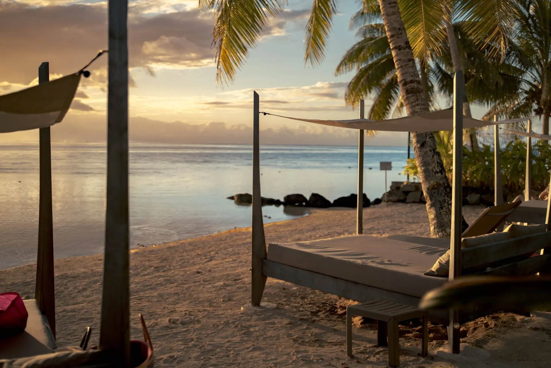 Lit balinais sur la plage au coucher du soleil