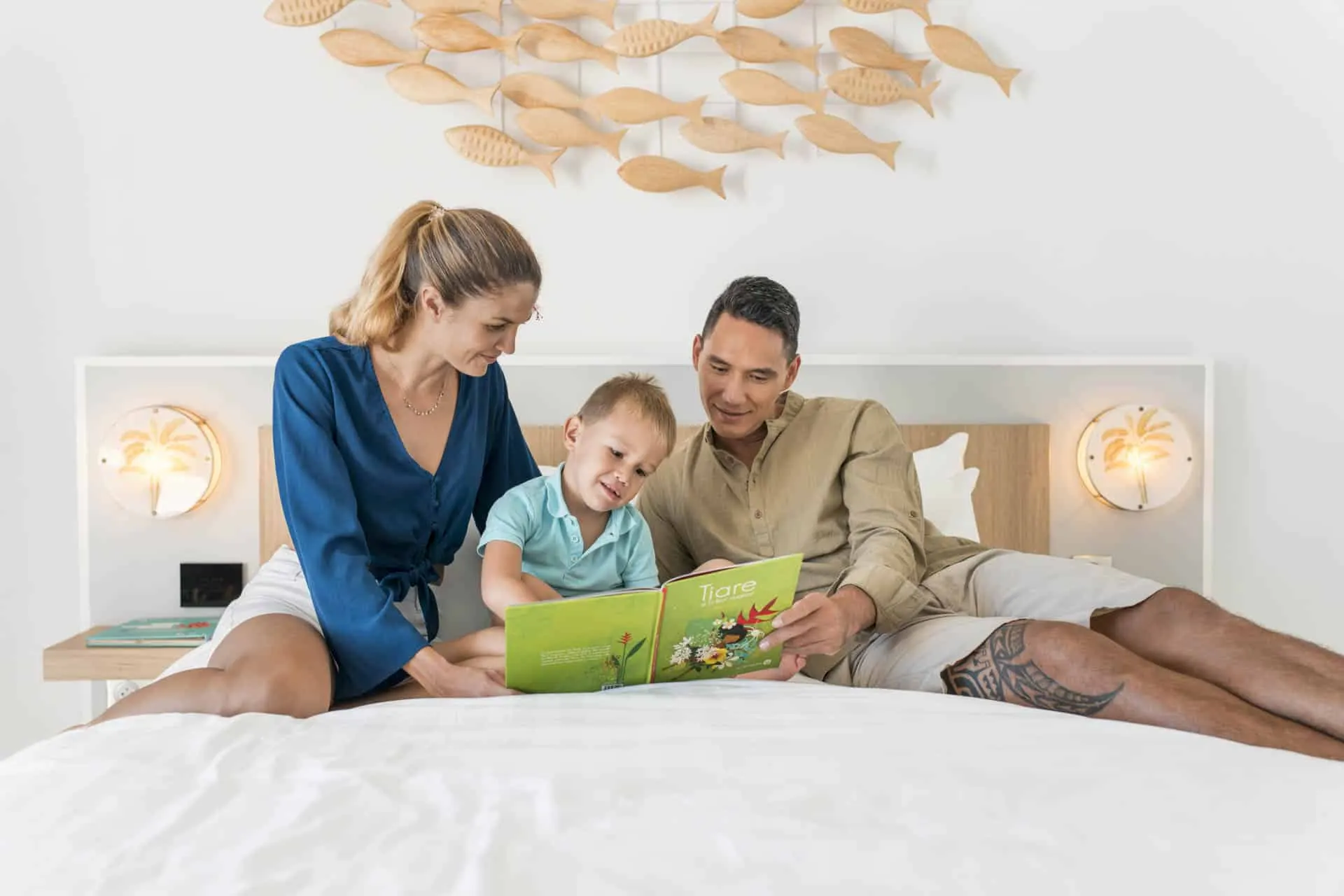 Famille lisant un livre sur le lit d'une suite