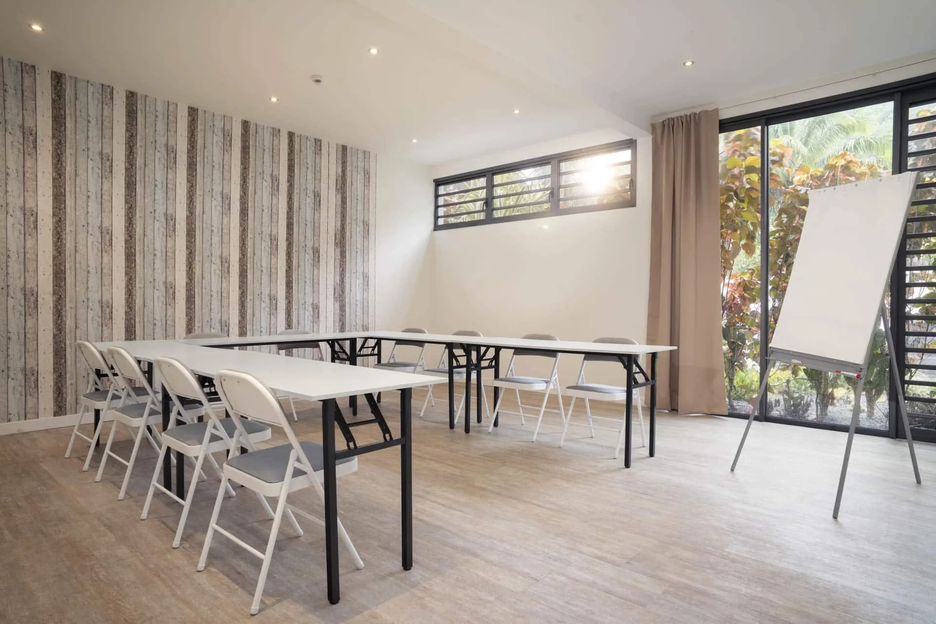 Salle de réunion lumineuse avec tables et paperboard